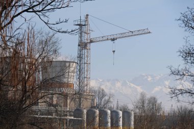 Almaty, Kazakistan - 02.04.2021: Isıtma tesisinin bölgesinde soğutma kulesi ve kule vinci