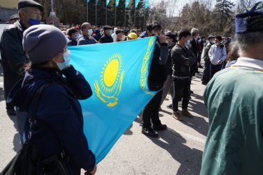 Almaty, Kazakistan - 03.27.2021: Çin 'in genişlemesine karşı düzenlenen mitingde insanlar Kazakistan bayrağını gerdi