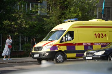 Almaty, Kazakistan - 05.04.2021: Kentin sokaklarından birinde bir ambulans trafikte.