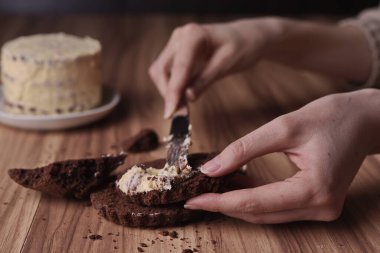 Spread the buttercream on the brownie slices to form the cake.