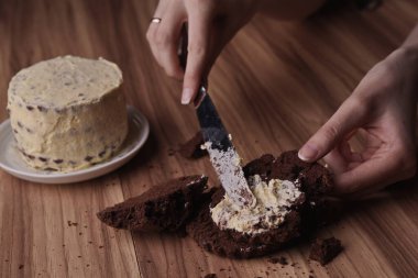 Spread the buttercream on the brownie slices to form the cake.