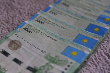 Almaty, Kazakhstan - 04.18.2016 : Banknotes with a nominal value of 2000 tenge are laid out on top of each other in a row clipart