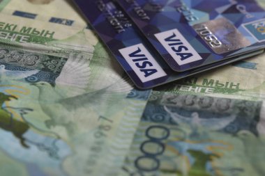 Almaty, Kazakistan - 04.18.2016: Kazakistan tenge banknotlarına vize kartları yerleştiriliyor.