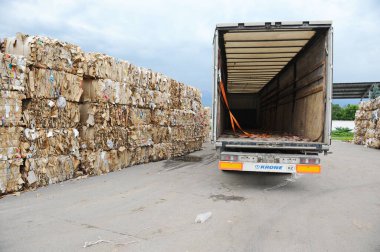 Almaty, Kazakistan - 07.01.2016: Karton fabrikasında özel ekipmanlar atık kağıt boşaltıyor.
