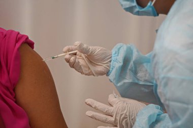 Almaty, Kazakistan - 08.11.2021: Doktor hastaya aşı yapar ve enjekte eder.