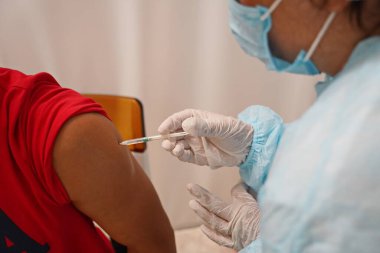 Almaty, Kazakistan - 08.11.2021: Doktor hastaya aşı yapar ve enjekte eder.