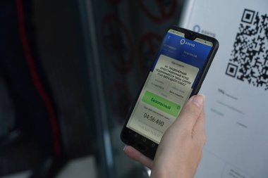 Almaty, Kazakistan - 08.11.2021: Alışveriş merkezini ziyaret edenler Ashyq sisteminden binaya girmek için QR kodunu tarayın.