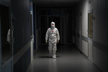 Almaty, Kazakistan - 09.03.2021: Bir doktor bir hastanede karanlık bir koridorda yürüyor