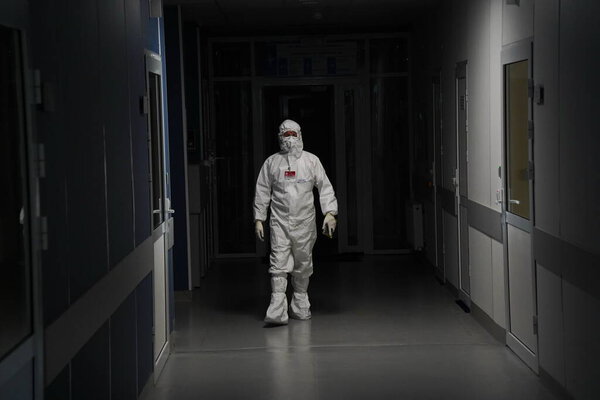 Алматы, Казахстан - 09.03.2021: Врач идет по темному коридору в больнице