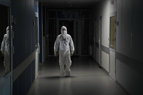 Алматы, Казахстан - 09.03.2021: Врач идет по темному коридору в больнице