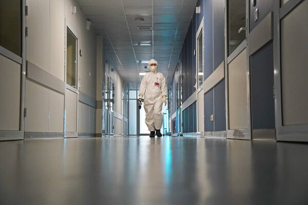 Алматы, Казахстан - 09.03.2021: Врач идет по коридору, где включена кварцевая лампа