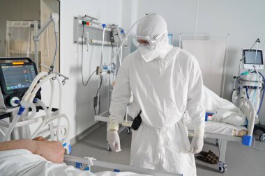 Almaty, Kazakistan - 09.03.2021: Doktor yoğun bakımda hastanın durumunu izliyor