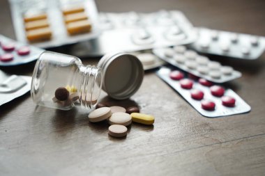 Almaty, Kazakistan - 09.13.2021: Cam kavanozdan tabletler ve kabarcıklardaki ilaçlar masada