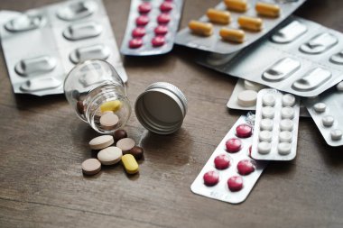 Almaty, Kazakistan - 09.13.2021: Cam kavanozdan tabletler ve kabarcıklardaki ilaçlar masada