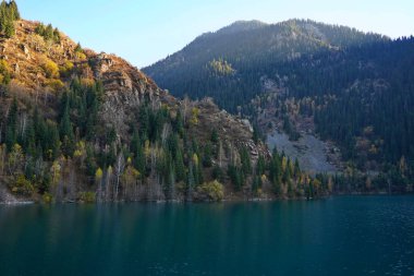 Lake Issyk in the rays of the setting sun. National Nature Park. Mountainous area with different vegetation.