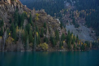 Lake Issyk in the rays of the setting sun. National Nature Park. Mountainous area with different vegetation.