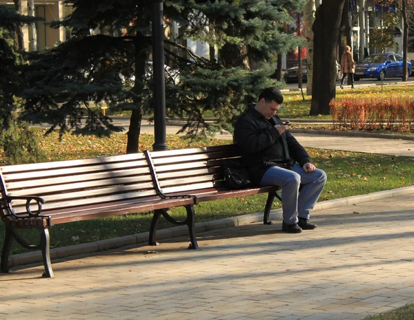 Неизвестный сидит на скамейке — стоковое фото
