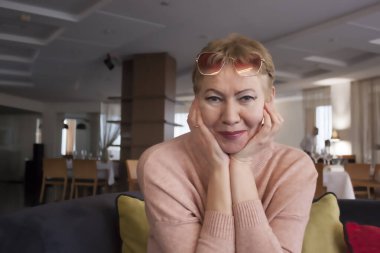 Bilinmeyen bir restoranın içinde çekici olgun bir kadın.