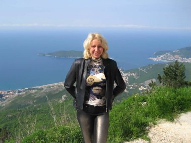 Nisan 'ın sonlarında güneşli bir günde dağ yamacında genç çekici bir kız. Aşağıda - Adriyatik Denizi