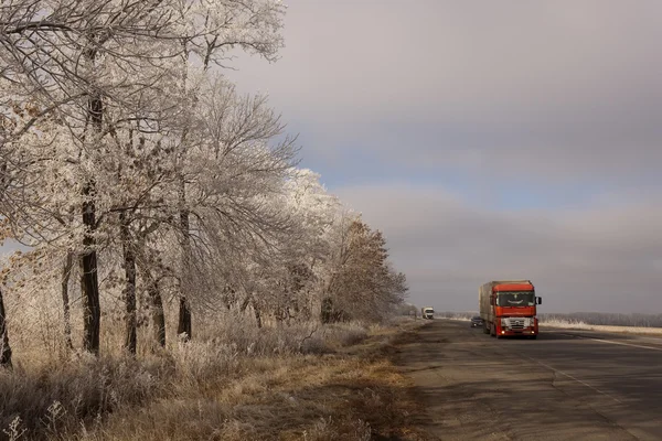 Röd tunga fordon på vintern vägen — Stockfoto