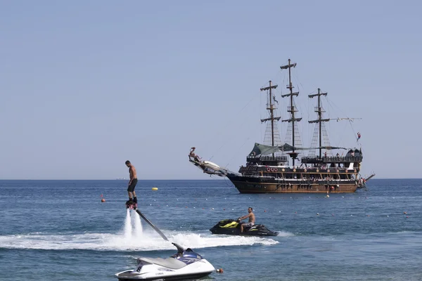 Флайборд и яхтенная стилизованная пиратская шхуна — стоковое фото