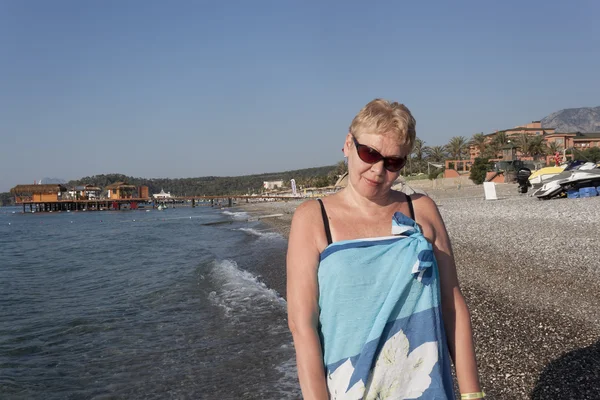 Mujer de mediana edad en pareo y gafas de sol — Foto de Stock