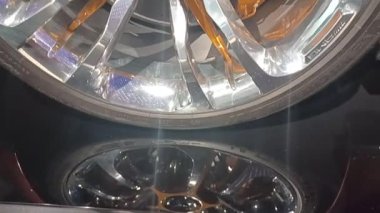 STUTTGART, GERMANY - 18 Ekim 2025: Benzersiz, parlak bir Mercedes-AMG araba tekerleğinin yakın plan videosu, parlak krom ve altın renkli teller, fren kalibresini ve Mercedes logosunu gösteriyor