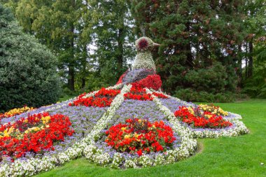 The magnificent peacock made of flowers at the famous Mainau Island garden on Lake Constance, showcasing vibrant colors and stunning horticultural art under a clear blue sky