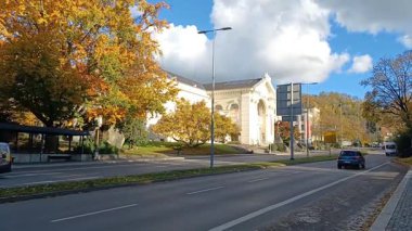 RAVENSBURG, GERMANY - 24 Ekim 2025: Parlayan ışıkları ve sireniyle güneşli bir sonbahar gününde Almanya 'nın Ravensburg kentindeki büyük tarihi bir binanın önünden geçen ambulans