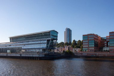 HAMBURG, GERMANY - 12 AĞUSTOS 2024: Hamburg Elbe Nehri rıhtımındaki modern cam ofis kompleksi. Altona liman bölgesinde, mavi gökyüzünün altında çağdaş mimari