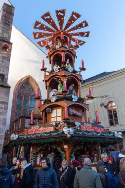 BASEL, SWitzERLAND - 16 Aralık 2024: Geleneksel bir Alman ahşap Noel piramidinin mumlar ve heykelciklerle aydınlatılmış ve Basel Noel Pazarı 'nda popüler bir tezgah olarak hizmet veren ayrıntılı bir yakın çekimi
