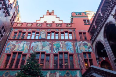 BASEL, SWitzERLAND - 16 Aralık 2024: Basel Belediye Binası (Rathaus) iç avlusunun ön cephesi, basamaklı, canlı kırmızı duvarlar ve büyük, renkli bir tarihi fresk