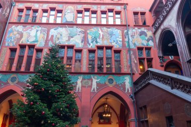 BASEL, SWitzERLAND - 16 Aralık 2024: Basel Belediye Binası (Rathaus) iç avlusunun ön cephesi, basamaklı, canlı kırmızı duvarlar ve büyük, renkli bir tarihi fresk
