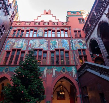 BASEL, SWitzERLAND - 16 Aralık 2024: Basel Belediye Binası (Rathaus) iç avlusunun ön cephesi, basamaklı, canlı kırmızı duvarlar ve büyük, renkli bir tarihi fresk