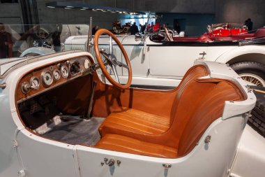 STUTTGART, GERMANY - 18 Ekim 2025: Bronz deri koltuklar, ahşap direksiyon ve analog göstergeli retro gösterge paneli içeren klasik beyaz klasik bir spor arabanın ayrıntılı iç mekanı