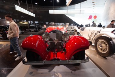 STUTTGART, GERMANY - 18 Ekim 2025: Efsanevi 1934 Mercedes-Benz 500 K Özel Roadster (W 29) parlak kırmızı. Stuttgart 'taki Mercedes-Benz Müzesi' nde ikonik krom ızgaralı lüks klasik araba ve egzoz boruları var.