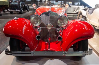 STUTTGART, GERMANY - 18 Ekim 2025: Efsanevi 1934 Mercedes-Benz 500 K Özel Roadster (W 29) parlak kırmızı. Stuttgart 'taki Mercedes-Benz Müzesi' nde ikonik krom ızgaralı lüks klasik araba ve egzoz boruları var.