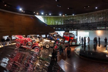 STUTTGART, ALMANY - 18 Ekim 2025: Mercedes-Benz Müzesi 'nin içi ilk tarihsel otomobil koleksiyonunu gösteriyor. Modern mimari sergi alanında yürüyen ziyaretçiler