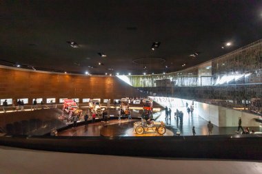 STUTTGART, ALMANY - 18 Ekim 2025: Mercedes-Benz Müzesi 'nin içi ilk tarihsel otomobil koleksiyonunu gösteriyor. Modern mimari sergi alanında yürüyen ziyaretçiler