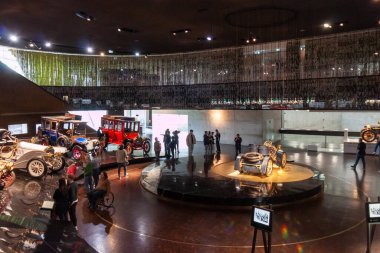STUTTGART, ALMANY - 18 Ekim 2025: Mercedes-Benz Müzesi 'nin içi ilk tarihsel otomobil koleksiyonunu gösteriyor. Modern mimari sergi alanında yürüyen ziyaretçiler