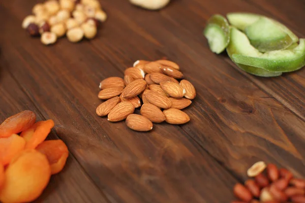 Nüsse und Trockenfrüchte auf Holzgrund — Stockfoto