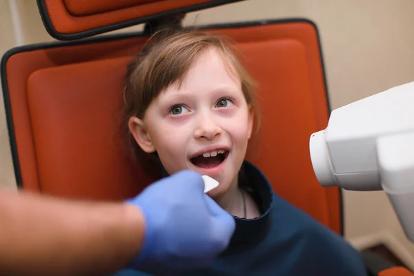 Bir dişçi intraoral kalkan çocuklar hasta ağız ve diş Kliniği, x-ray makinesi yönetmenlik Yardımcısı koyarak kapatın — Stok fotoğraf