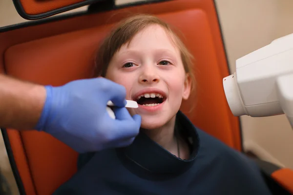 Bir dişçi intraoral kalkan çocuklar hasta ağız ve diş Kliniği, x-ray makinesi yönetmenlik Yardımcısı koyarak kapatın — Stok fotoğraf