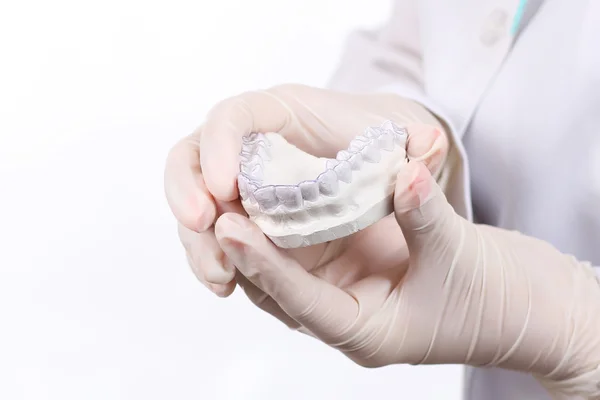 Primo piano di medici mani in guanti che tengono il paradenti in silicone. Cura dei denti — Foto Stock