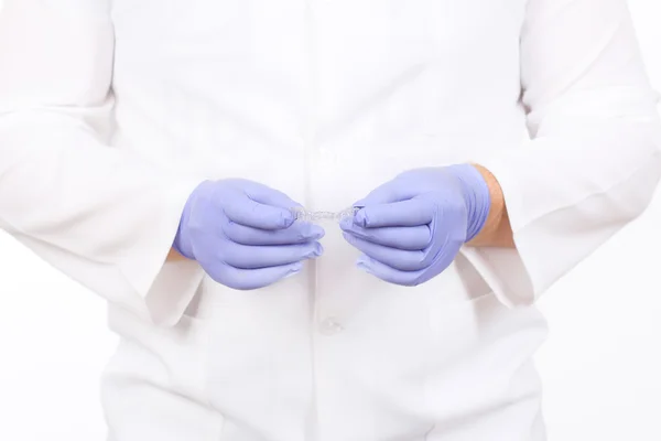 Primer plano de los médicos manos en guantes con protector bucal de silicona. Cuidado de los dientes —  Fotos de Stock