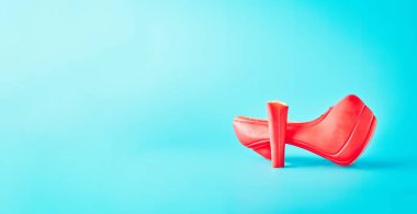 Mavi arka planda çikolatalı kadın ayakkabıları. Kırık ayakkabı, kadın problemi.