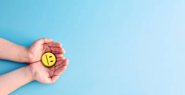 Dünya Akıl Sağlığı Günü konsepti. Mavi kağıt tutarken mutlu gülücük, olumlu düşünce, zihinsel sağlık değerlendirmesi. .