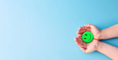 Dünya Akıl Sağlığı Günü konsepti. Mavi kağıt tutarken mutlu gülücük, olumlu düşünce, zihinsel sağlık değerlendirmesi. .