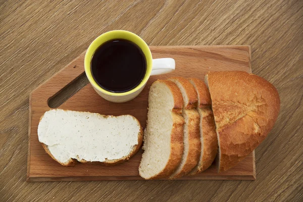 Vers broodje met kaas op een houten bord met koffie bij het ontbijt — Stockfoto