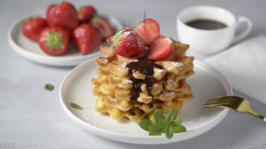 Çilekli waffle ve çikolata sosu. Tatlı kahvaltı yemeği.